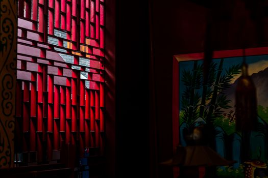 Bangkok, Thailand - Aug 01, 2020 : Light shines through the vent shade in the Chinese shrine's. Selective focus.