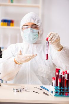 Young handsome lab assistant testing blood samples in hospital 