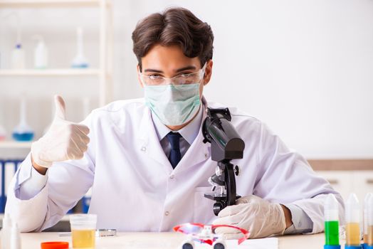 Young handsome chemist working in the lab