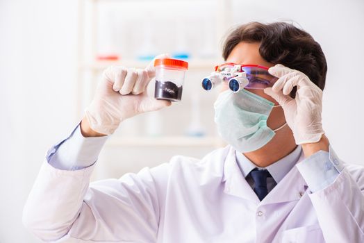 Young handsome chemist working in the lab