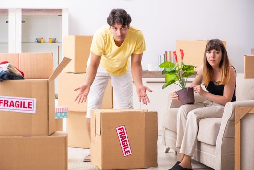 Young couple moving to new flat with fragile things