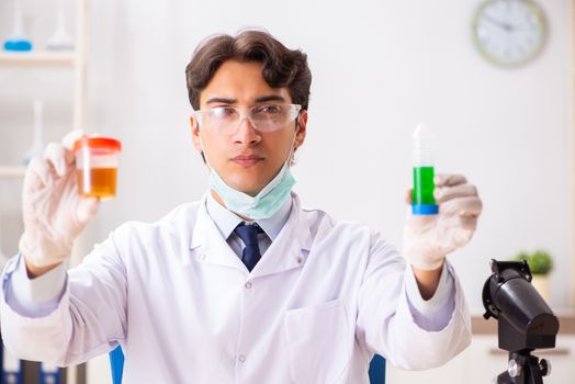 Young handsome chemist working in the lab