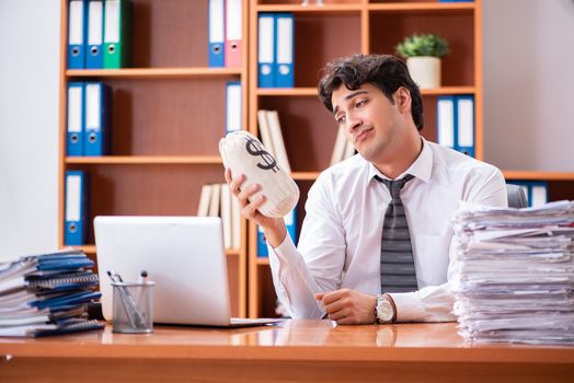 Young handsome businessman unhappy with excessive work 