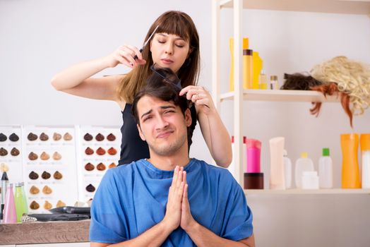 Young attracrive man visiting female barber 