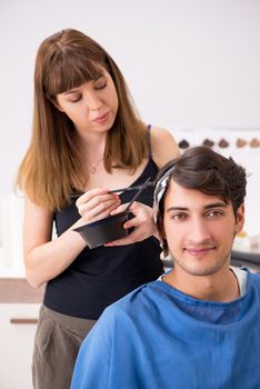 Young attracrive man visiting female barber 