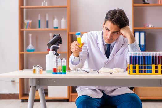 Young handsome biochemist working in the lab 