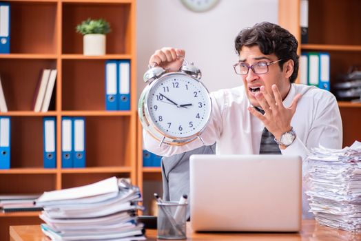 Young handsome businessman unhappy with excessive work 