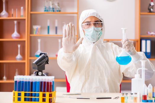 Young biochemist wearing protective suit working in the lab