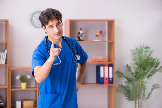 Young handsome doctor working in the hospital 