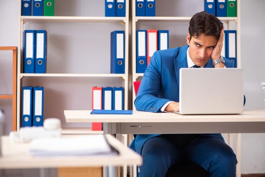 Young handsome businessman working in the office 