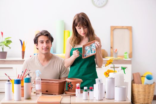 Couple decorating pots in workshop during class