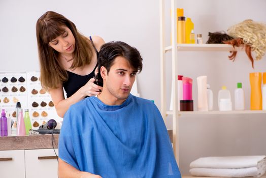 Young attracrive man visiting female barber 