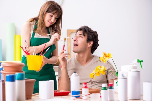 Couple decorating pots in workshop during class