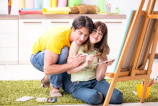 Young couple enjoying painting at home