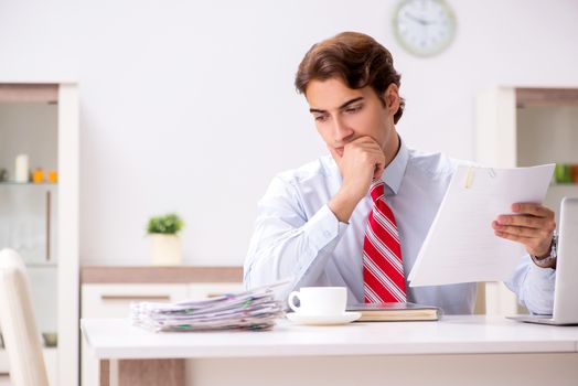 Young attractive businessman working in the office  