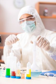 Young biochemist wearing protective suit working in the lab