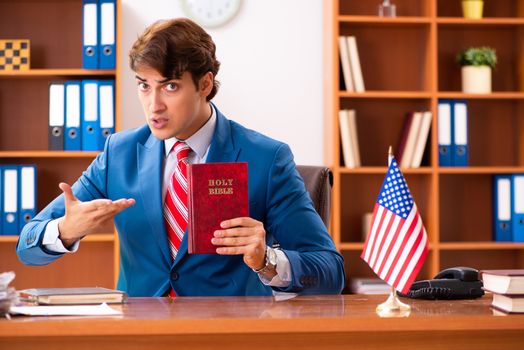 Young handsome politician sitting in office 