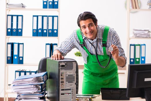 Young engineer repairing broken computer at the office 