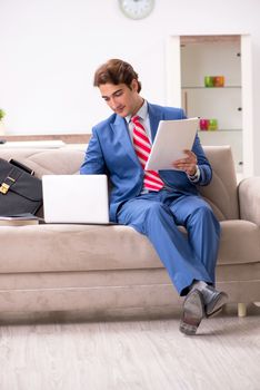 Young businessman working at home sitting on the sofa  