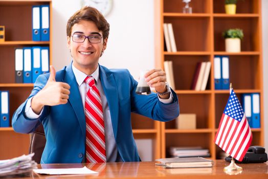 Young handsome politician sitting in office 