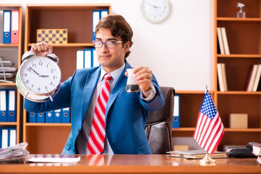 Young handsome politician sitting in office 