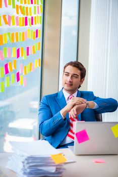 Young handsome employee with many conflicting priorities   