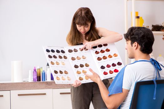 Young attracrive man visiting female barber 