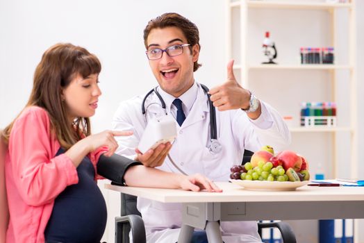 Pregnant woman visiting doctor discussing healthy diet