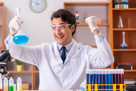 Young handsome biochemist working in the lab 