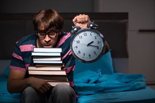 Young handsome student preparing for exams at night