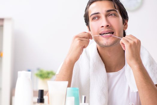 Young handsome man in the bathroom in hygiene concept 