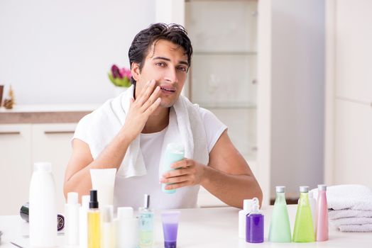 Young handsome man in the bathroom in hygiene concept 