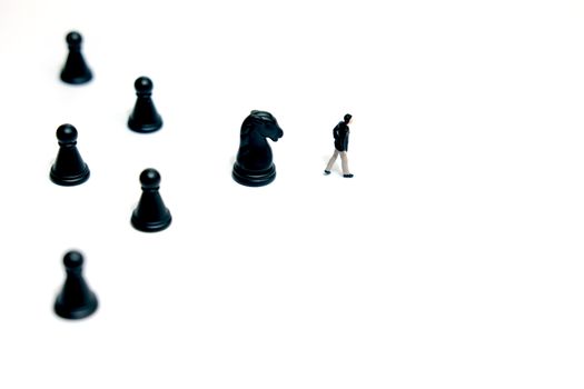 Miniature business concept - businessman walking forward with horse chess pawn. image photo