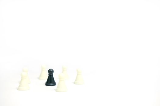 Miniature business strategy concept - black pawn standing between chess piece - front view