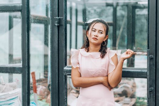 Portrait of asian woman posting and looking camera with glass house