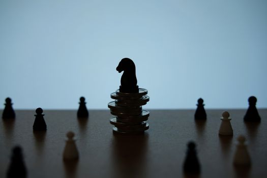 Silhouette of horse knight standing on coin stack with troops. image photo