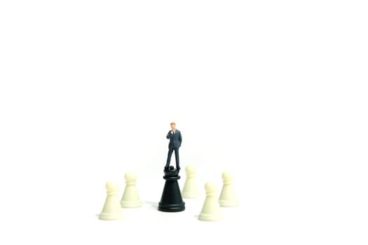 Miniature business concept - businessman standing on castle piece. image photo