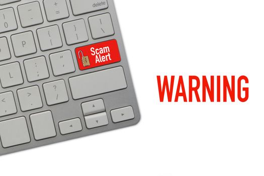 WARNING SCAM ALERT text on computer keyboard over white background. Business and Copy space concept