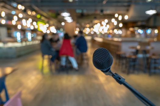 Microphone over the Abstract blurred photo of people group having the meeting in public working space or seminar room, misucal and education with modern lifestyle concept