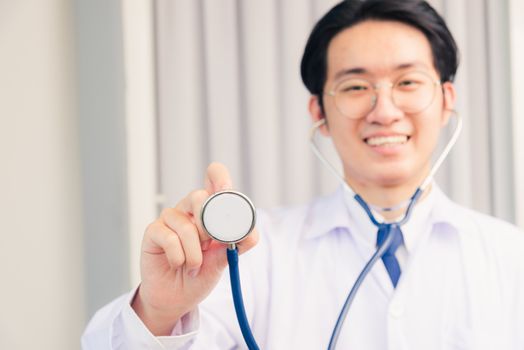 Portrait of Happy Asian young doctor handsome man smiling in uniform holding and show stethoscope, Healthcare medicine concept