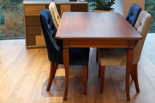 dining table and chairs in the living room by the large window