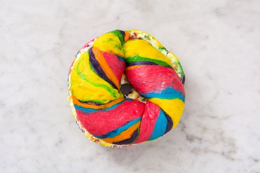 Colorful bagel with cheese and sprinkles on marble