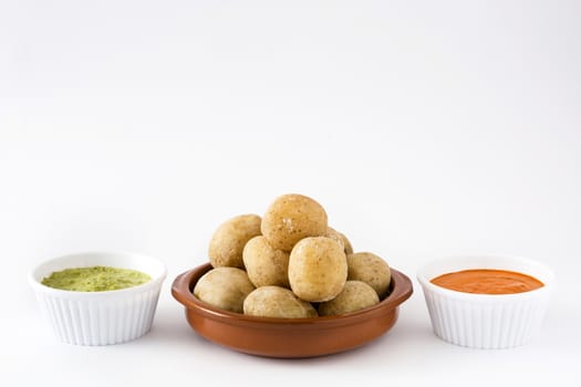 Canarian potatoes (papas arrugadas) with mojo sauce isolated on white background