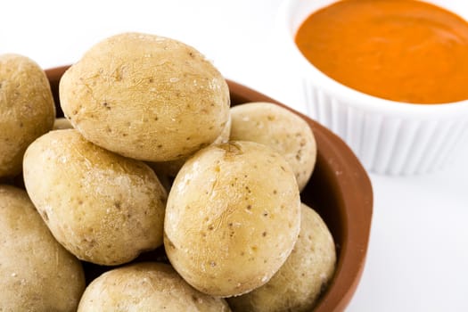 Canarian potatoes (papas arrugadas) with mojo sauce isolated on white background