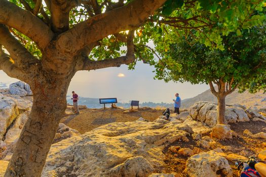 Arbel, Israel - August 14, 2020: View of the Sea of Galilee lookout in Mount Arbel National Park, at sunrise, with visitors. Northern Israel