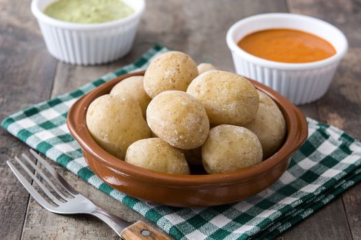 Canarian potatoes (papas arrugadas) with mojo sauce on wooden table