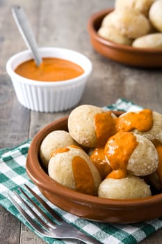 Canarian potatoes (papas arrugadas) with mojo sauce on wooden table