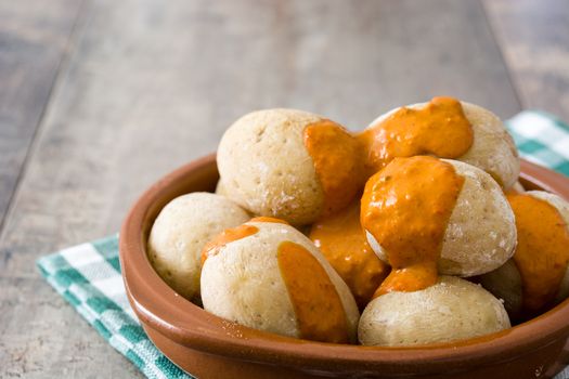 Canarian potatoes (papas arrugadas) with mojo sauce on wooden table