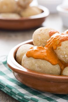 Canarian potatoes (papas arrugadas) with mojo sauce on wooden table