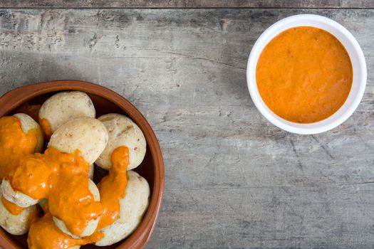 Canarian potatoes (papas arrugadas) with mojo sauce on wooden table